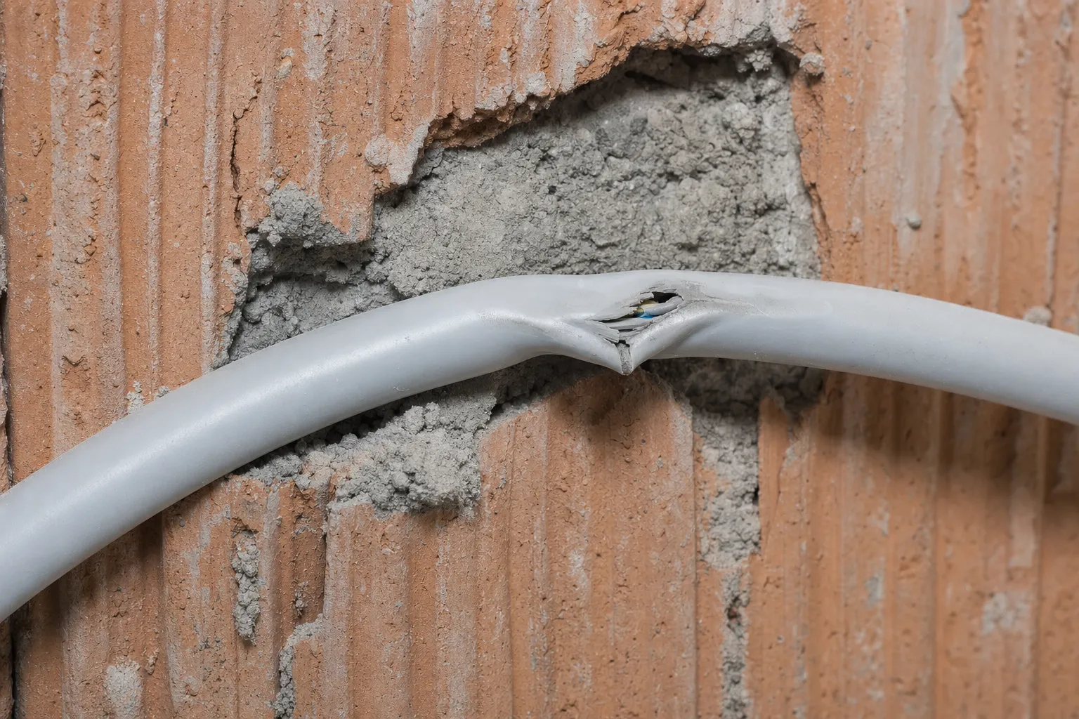 Gequetschte NYM-Elektroleitung mit eingedrückter Ummantelung – Motivbild zum Schadenstyp.